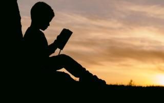 raamattua lukevan lapsen varjokuva